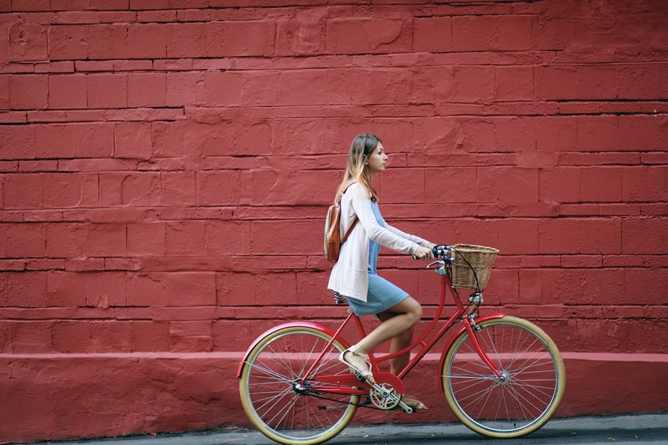 woman cycling by wall